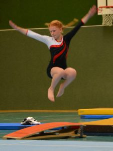 Elina macht einen Hocksprung am Boden