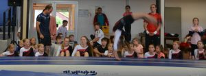 Flick-Flack auf der Airtrackbahn, dahinter Thorsten und die Ligaturnerinnen