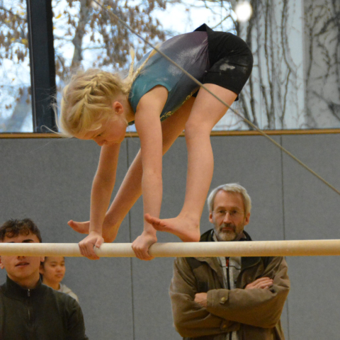 Frida setzt den Aufgrätschunterschwung an. Im Hintergrung Julian und Egbert
