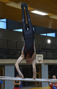 Philipp in der Handstand Drehung auf einem Barrenholm