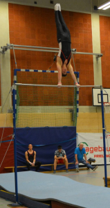 Patrick Kammgrifffelge Patrick im Handstand auf der Reckstange