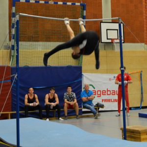 Philipp turnt den Stalder Philipp im gegrätschten Hang unter der Reckstange